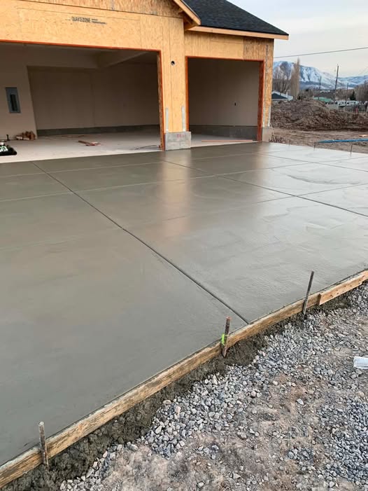Newly poured driveway flatwork in front of a garage